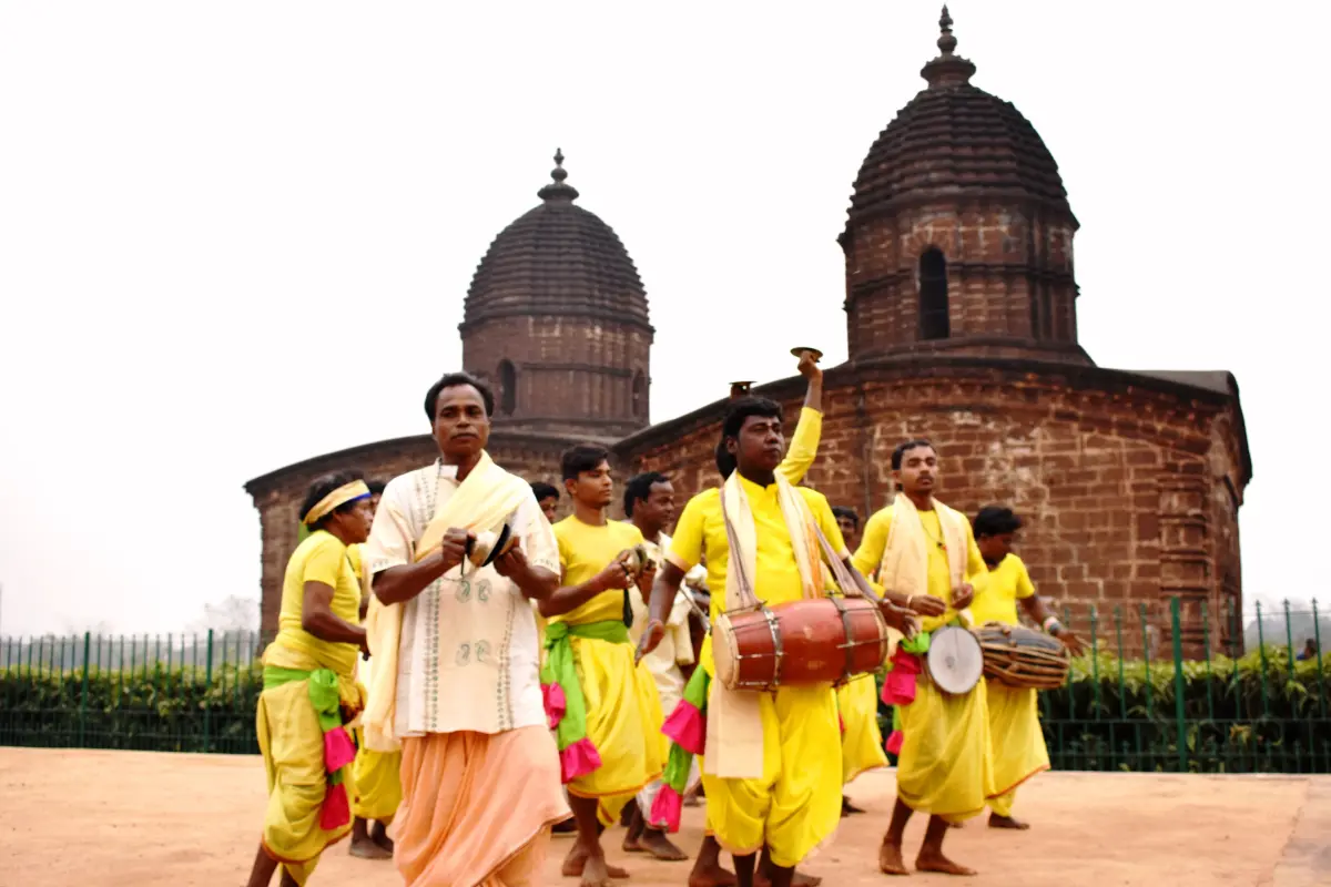 Musicians singing kirtan with cymbals and a khol drum in front of the Jor Mandir temple complex at Bishnupur, West Bengal