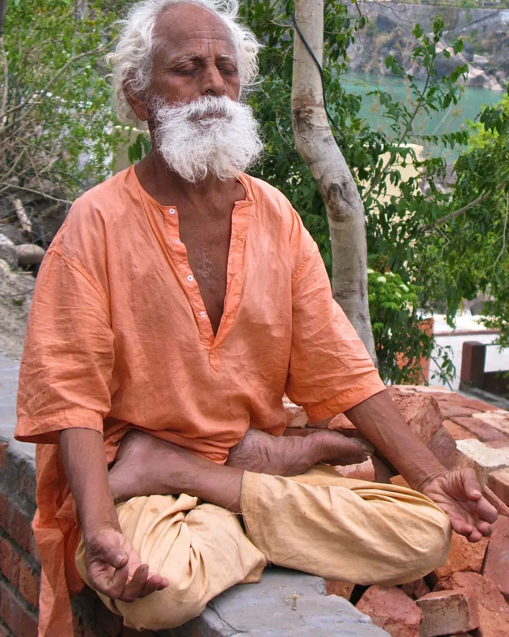 A sannyasi sitting cross-legged in meditation above the Ganga, Rishikesh