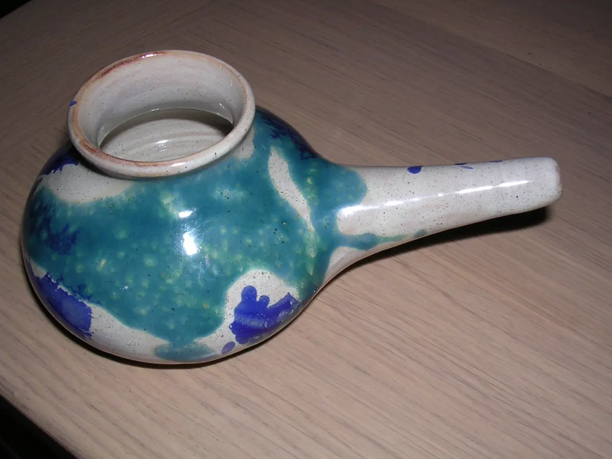 A glazed ceramic neti pot with a long spout, the small vessel used for jala neti, the nasal rinse with lukewarm salt water